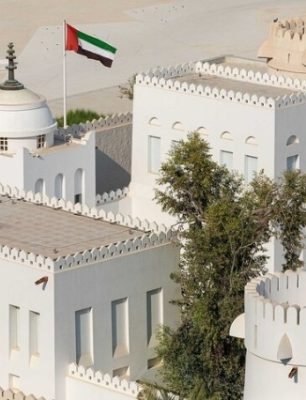 White architectural structures of Qasr Al Hosn with UAE flag, symbolizing cultural heritage and historical significance in Dubai.